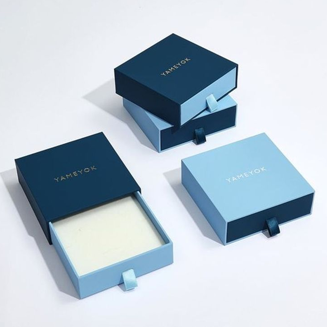 Elegant blue sliding drawer boxes with gold embossed logos.