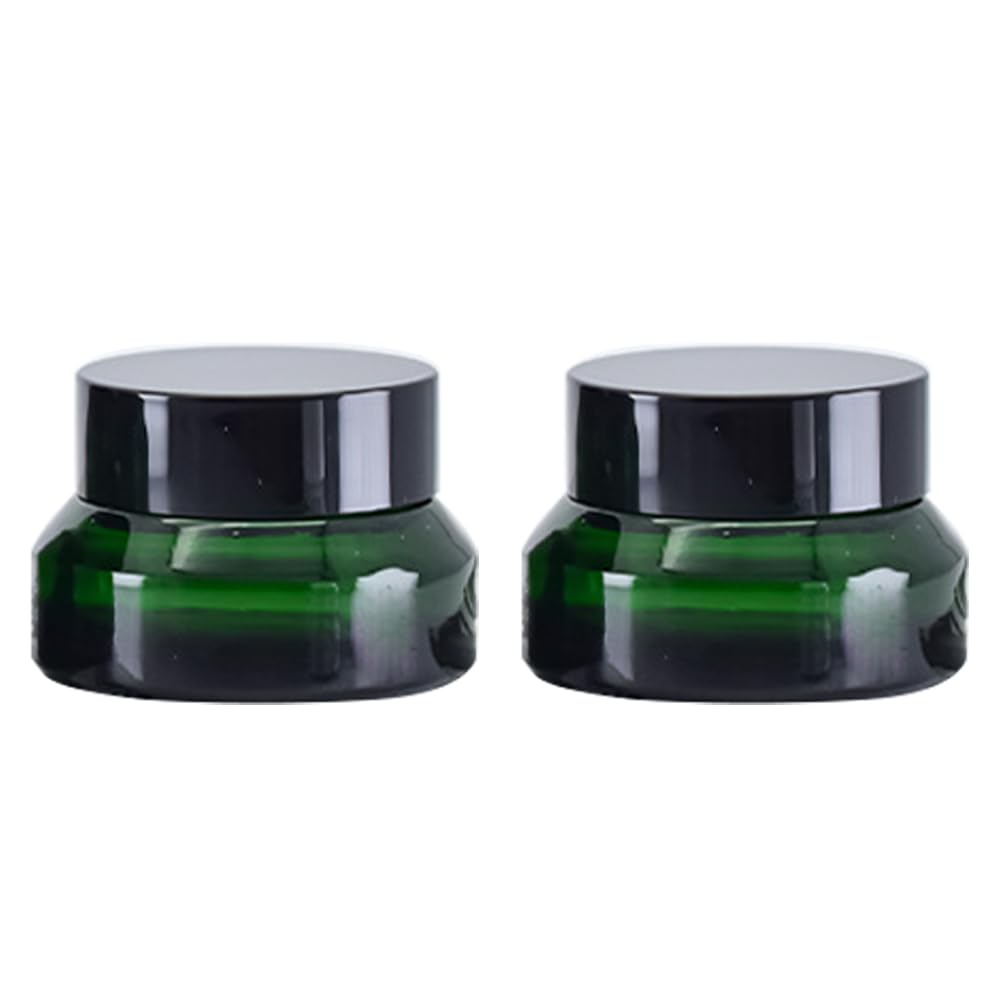 Two green cosmetic jars with black lids.