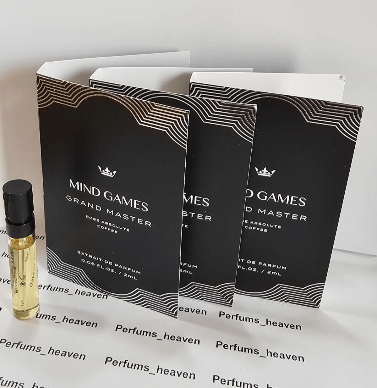 Mini fragrance sample bottles with black and white packaging.