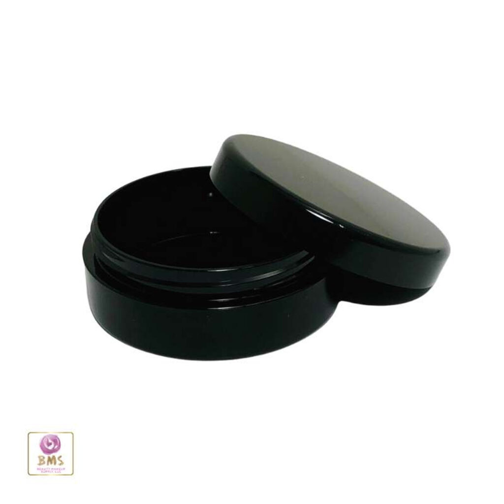 Black round container with open lid.