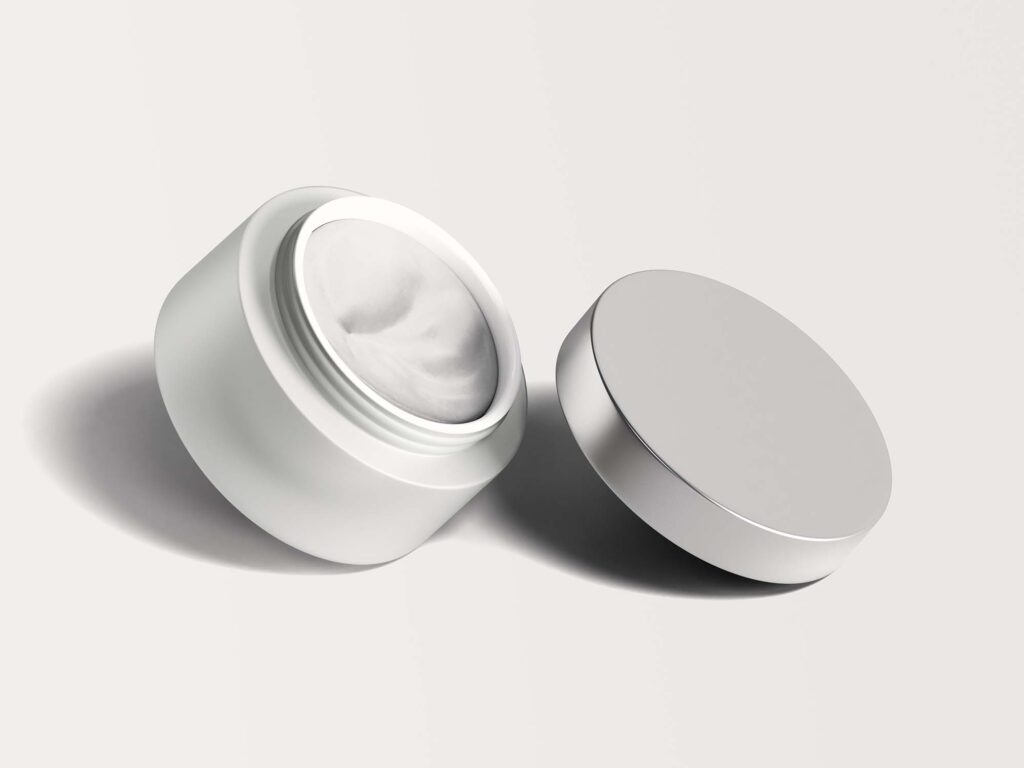 Open skincare cream jar with silver lid.