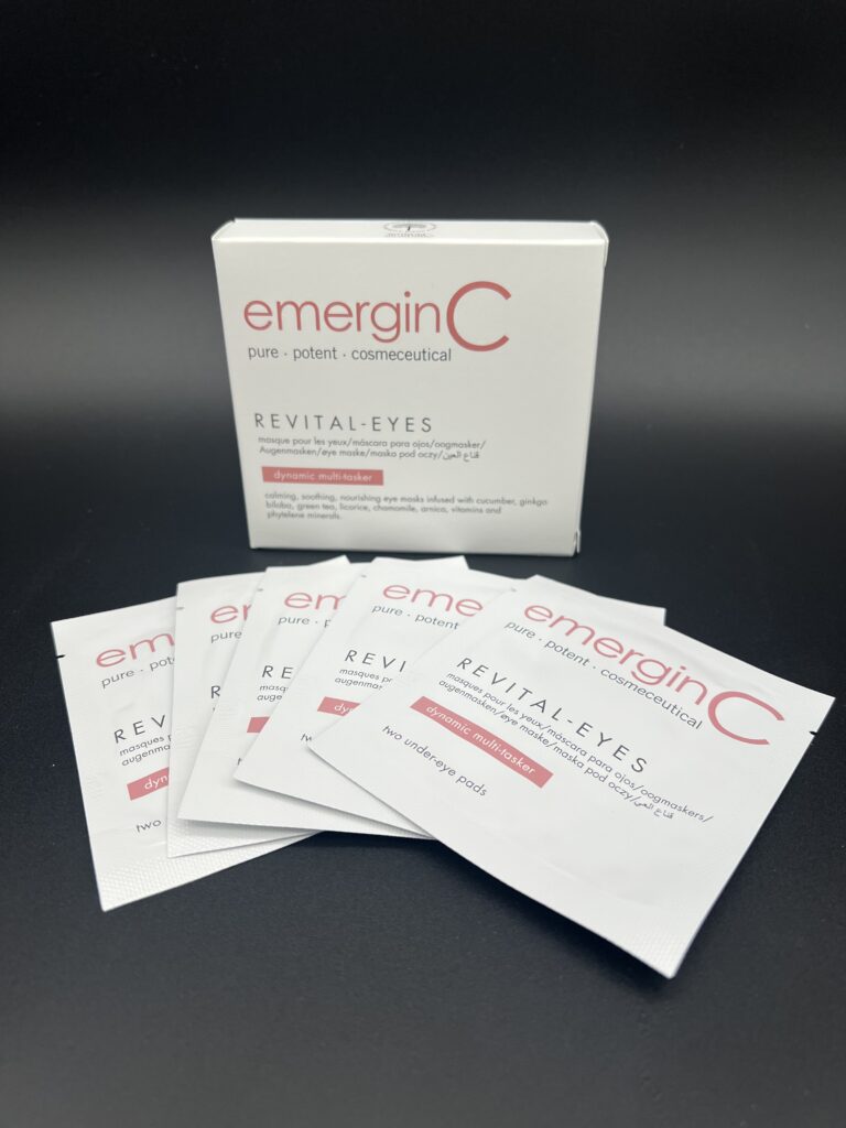 Emergen-C packets arranged in front of a product box on a dark surface.