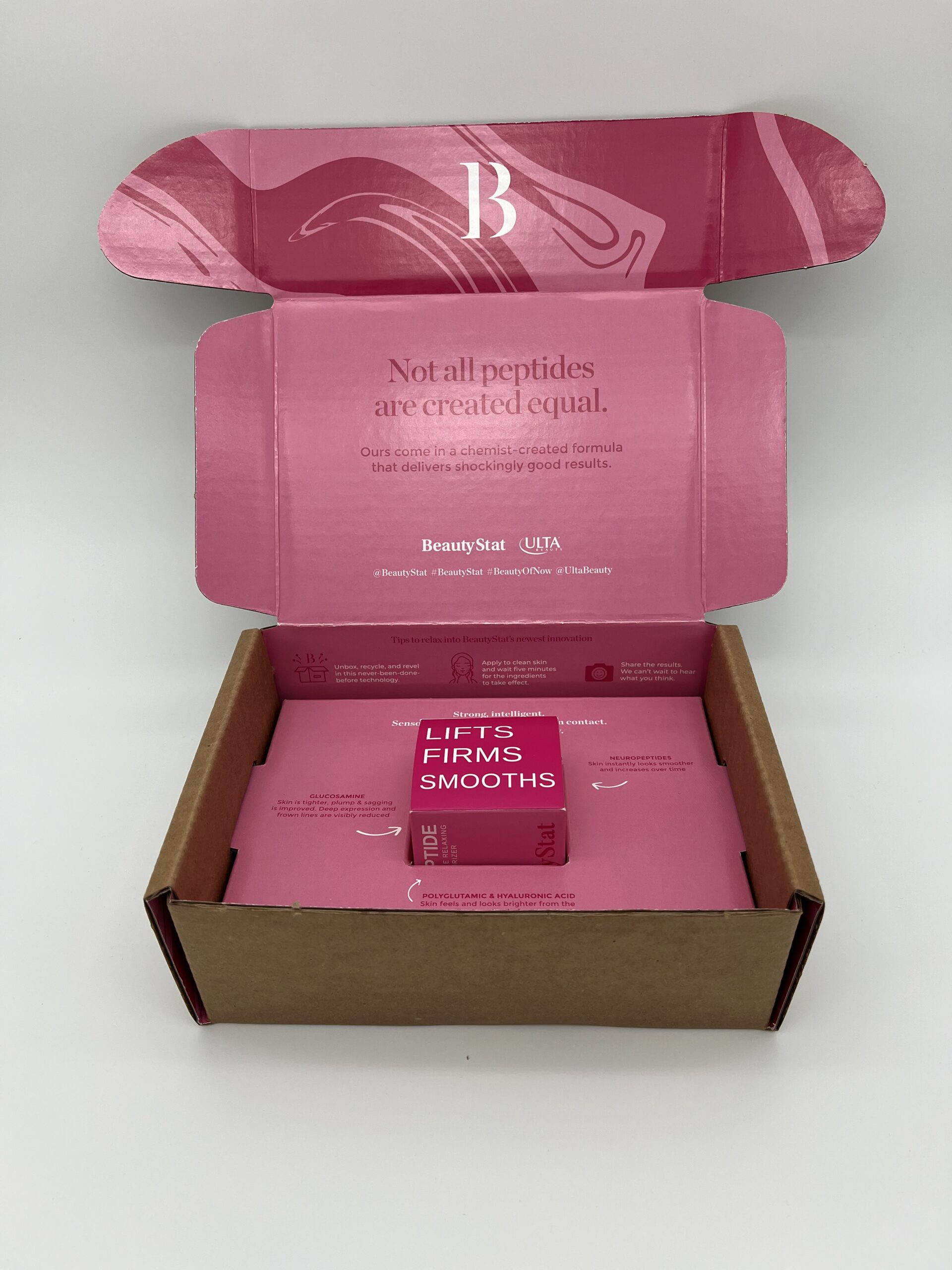 Pink-themed skincare product packaging with an open box and sachet inside.