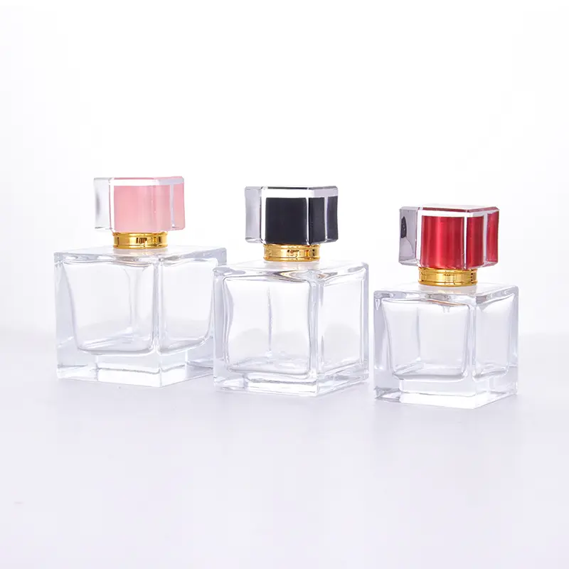 Three elegant square glass perfume bottles with pink, black, and red caps.