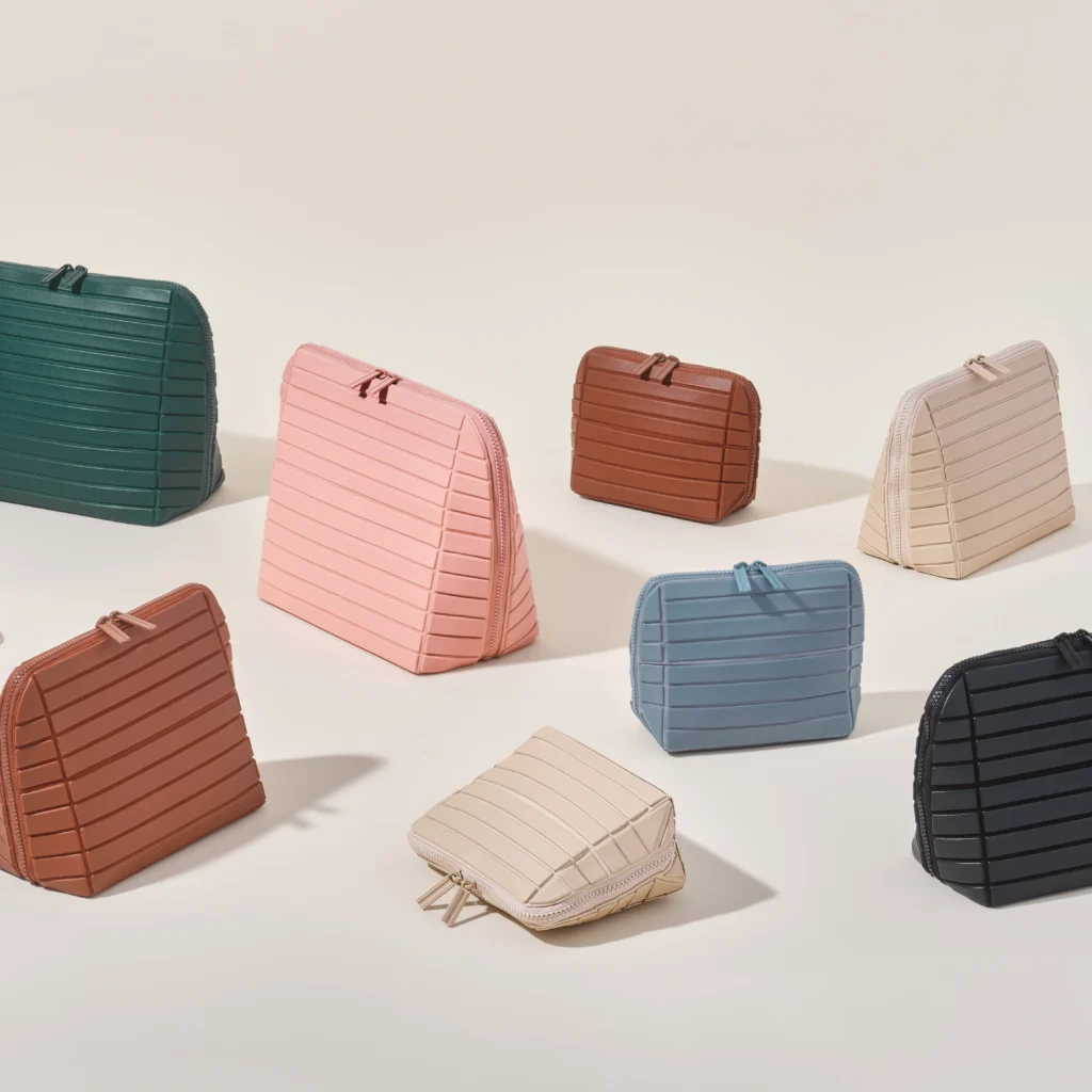 A collection of colorful quilted handbags in various shapes and sizes arranged on a light surface.