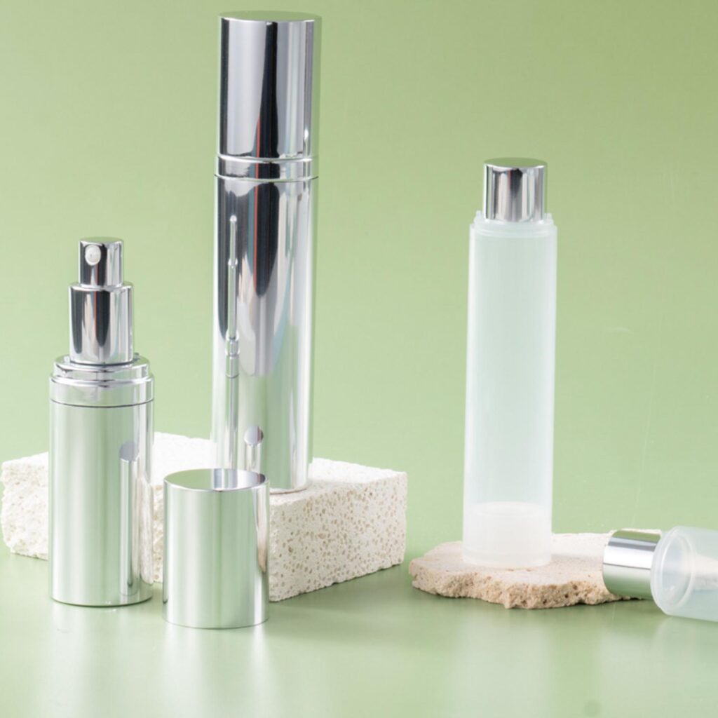 Three elegant cosmetic bottles with silver caps on a green background.