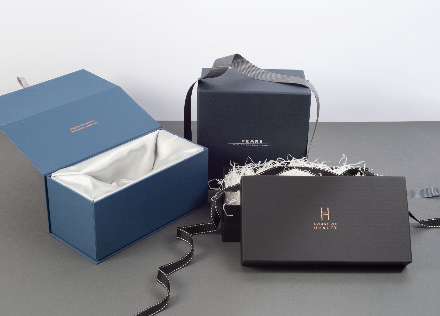 Luxury packaging boxes with satin ribbons and tissue paper.