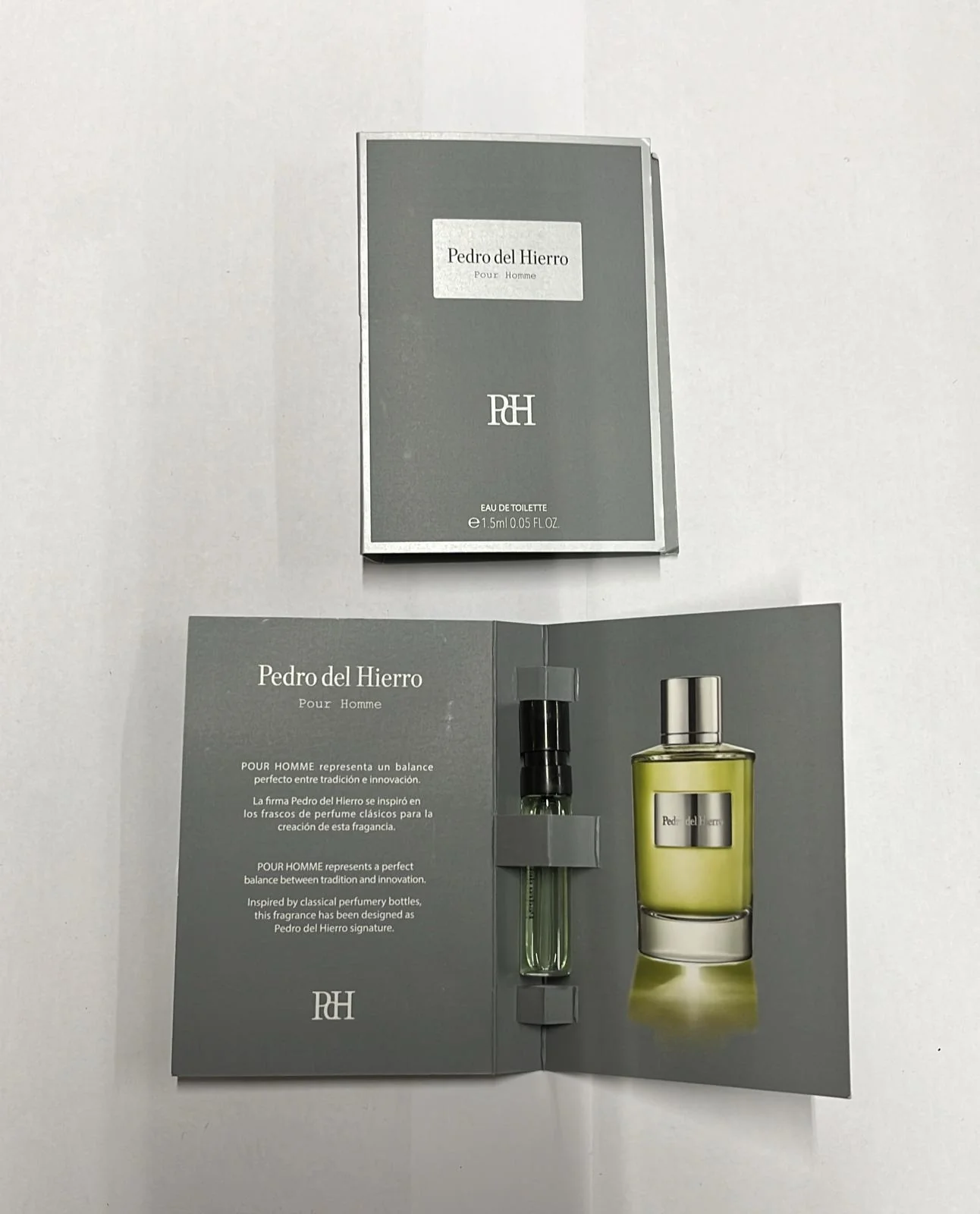 Open perfume sample packaging with a small spray bottle inside.