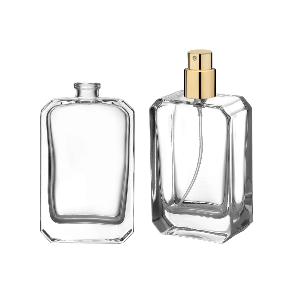 Two clear glass perfume bottles, one with a silver cap, the other with a gold spray nozzle.