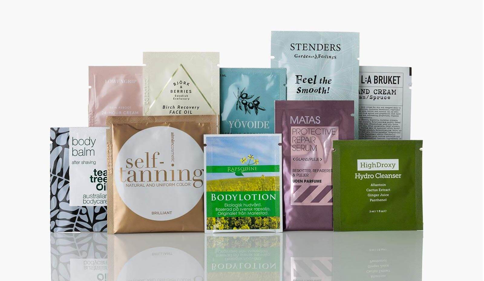 Assorted skincare and bath product samples arranged together on a white surface.
